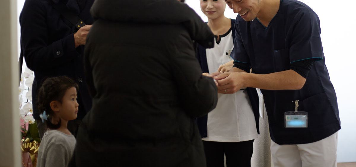 内覧会で名刺を渡すドクター